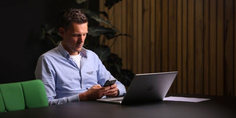 Kantoormedewerker werkt op beveiligde smartphone en laptop
