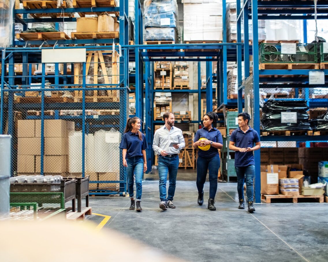 4 mensen lopen door groothandel met stellingen