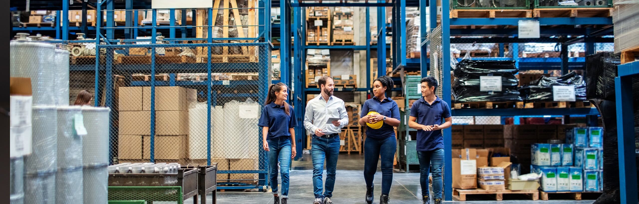 4 mensen lopen door groothandel met stellingen