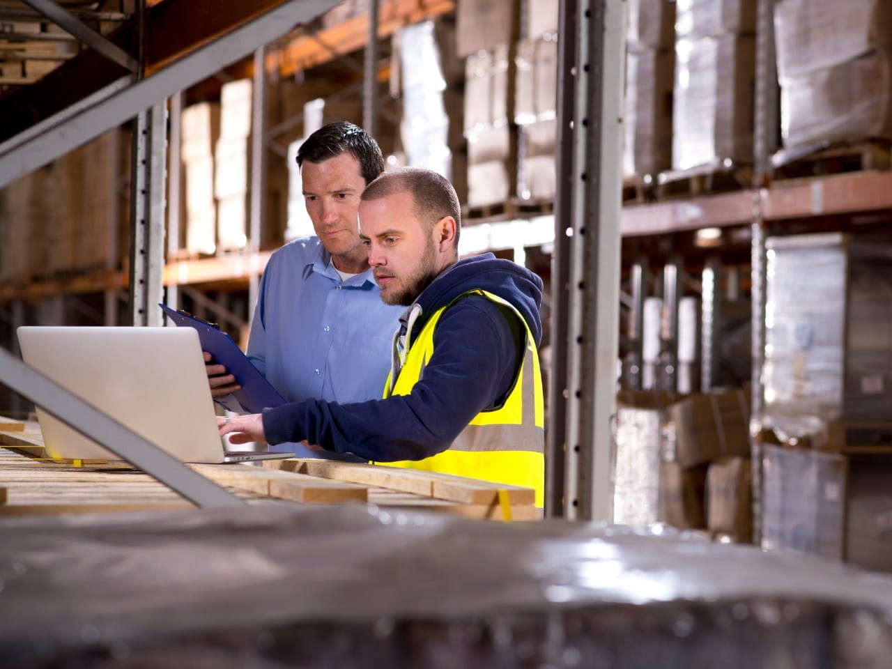 twee mannen in groothandel checken voorraad op laptop