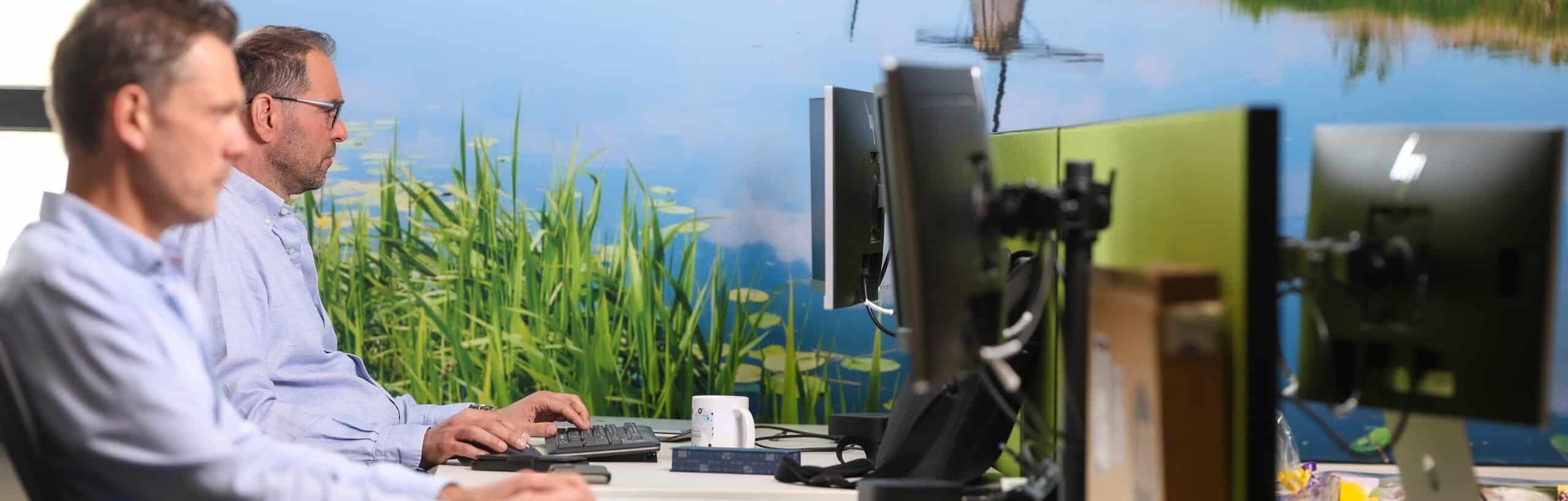 2 mannen werken achter hun computer bij it-bedrijf