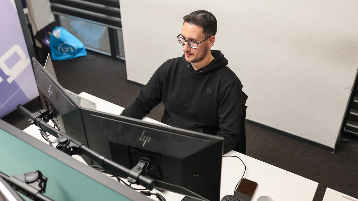 ict medewerker achter 2 computerschermen