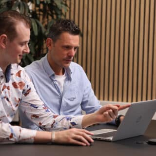 2 mannen zitten achter 1 laptop