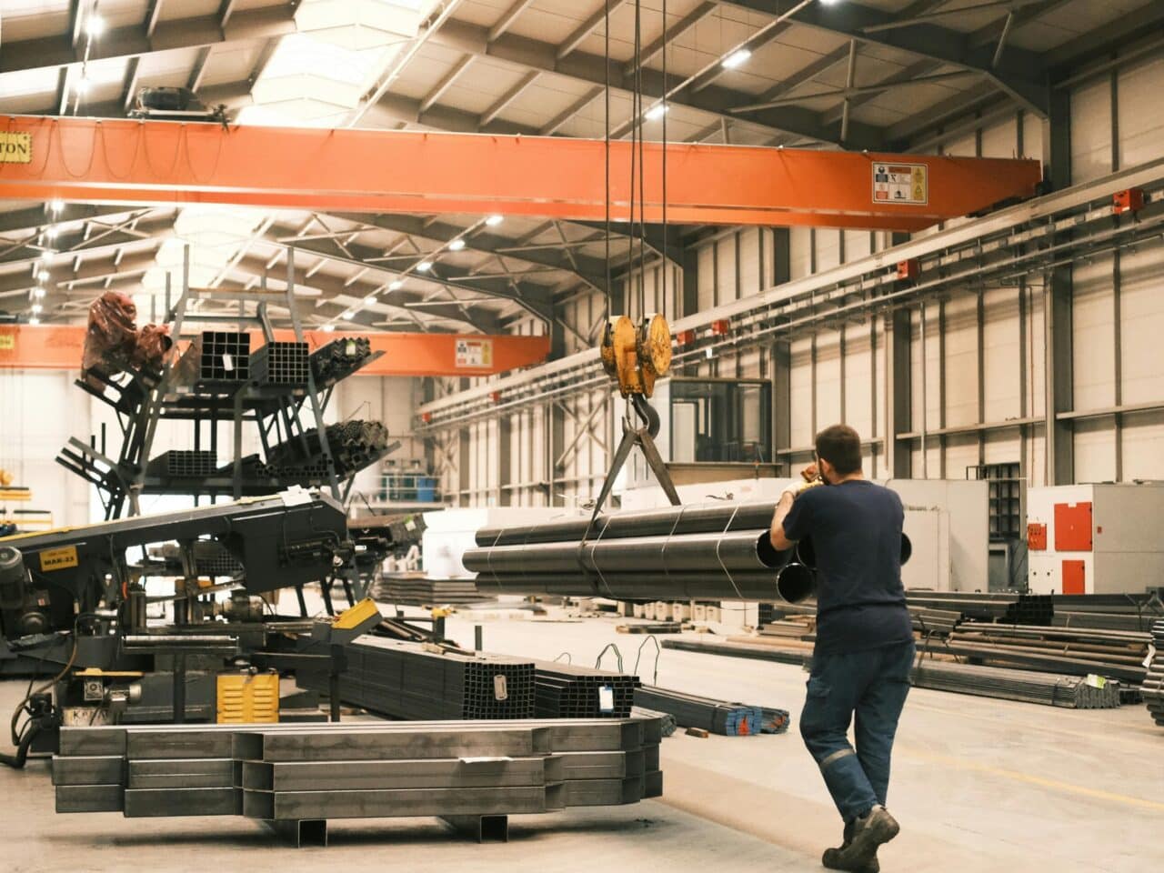 man transporteert buizen in productiehal
