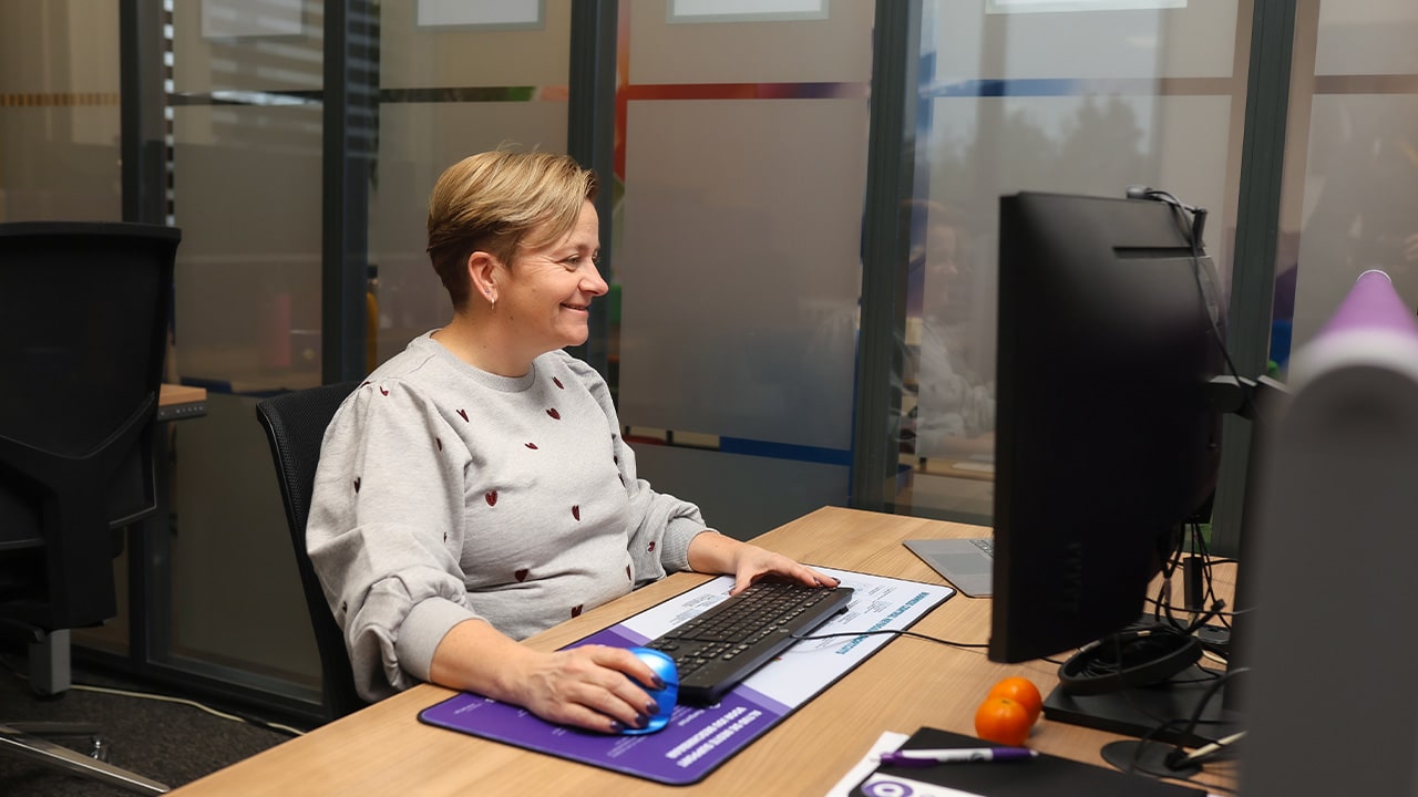 Vrouwelijke ERP Consultant werkt achter desktop