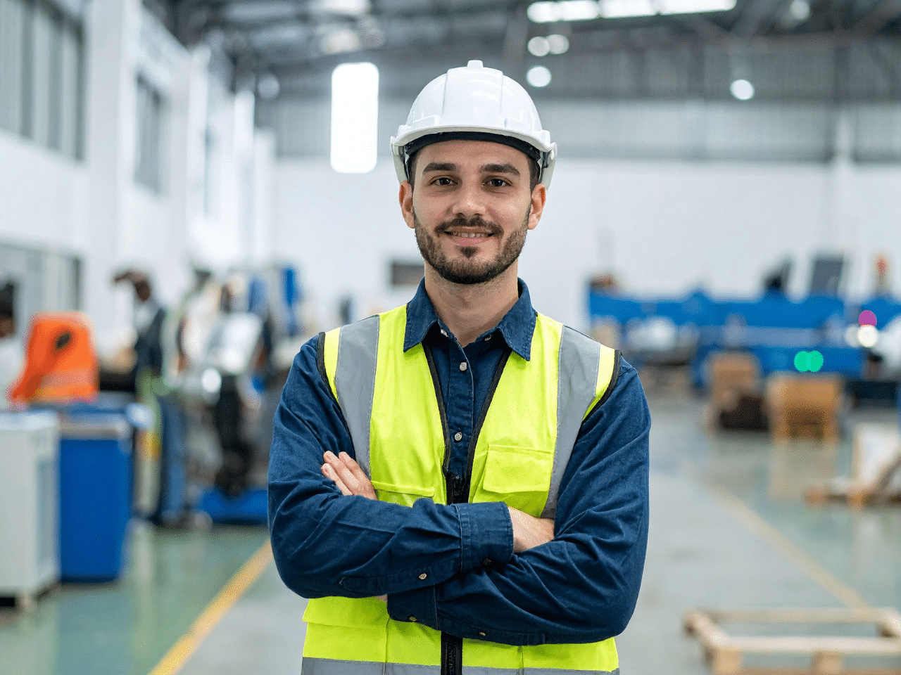 man met helm en hesje in industriehal