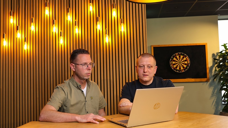 2 mannen werken samen achter laptop