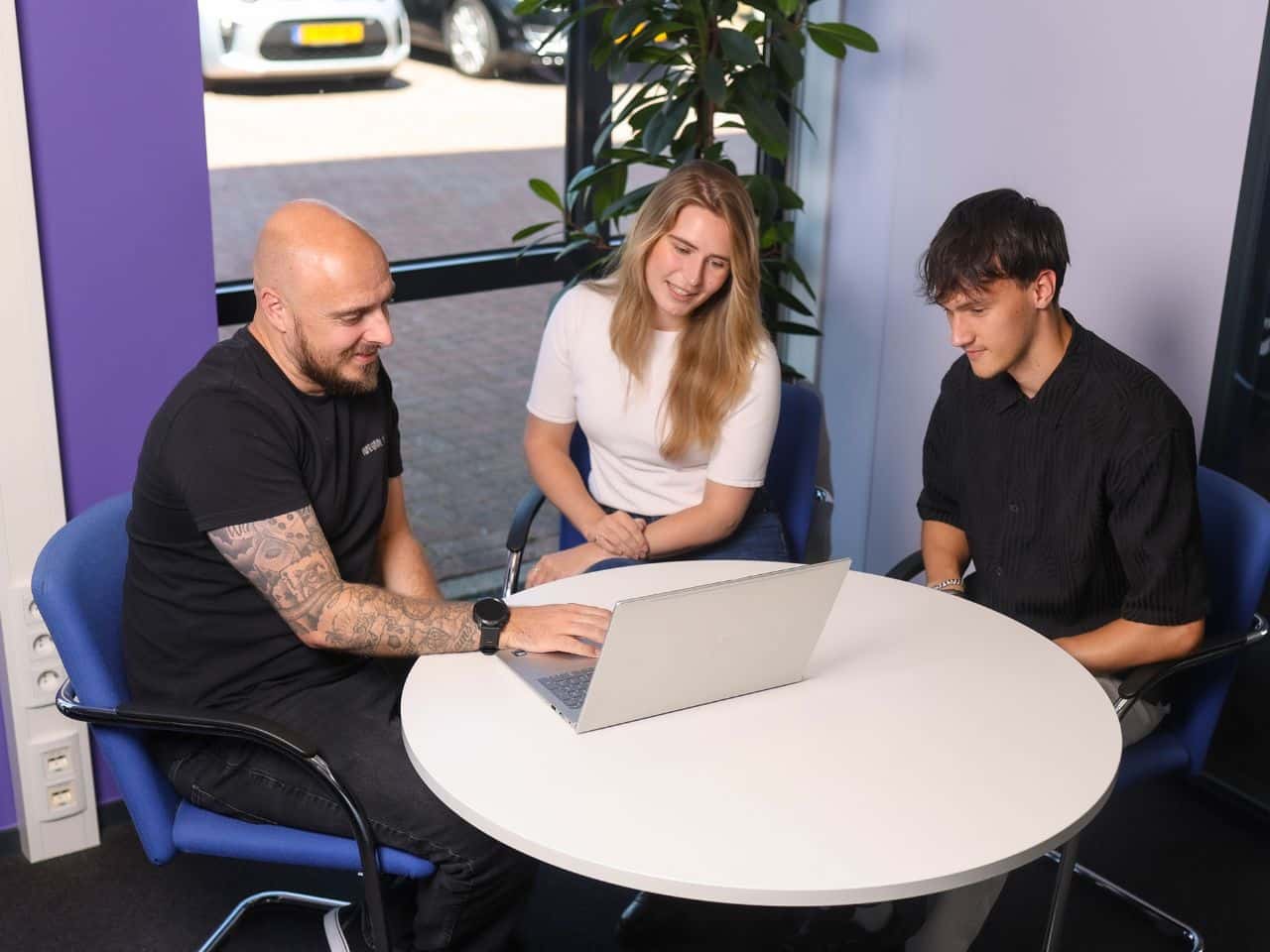 3 collega's werken achter laptop